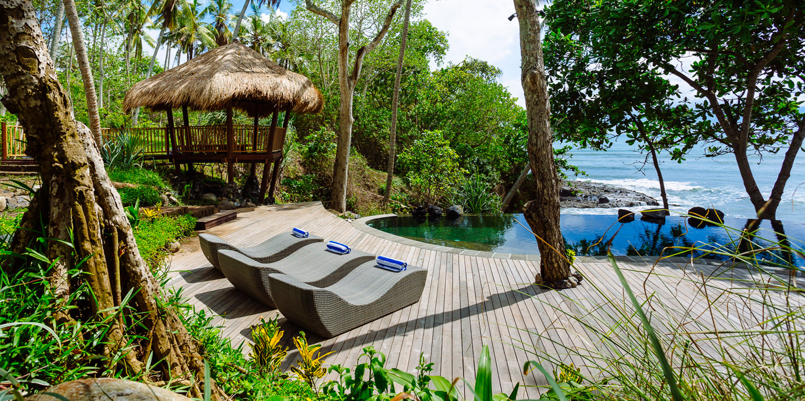 Swimming pool and lounge chairs in a beachfront Bali villa