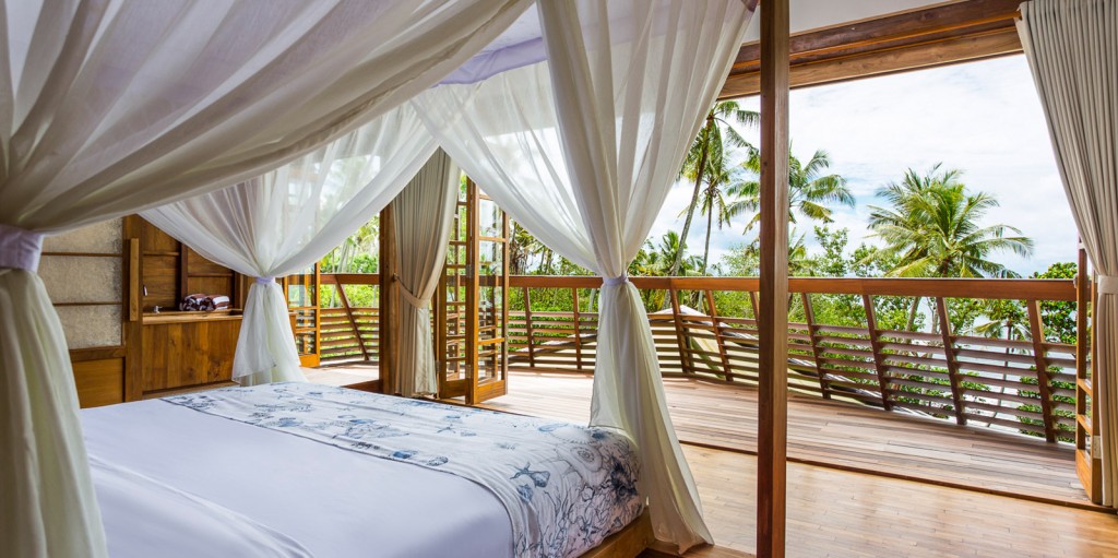 Bedroom in a beachfront holiday villa with expansive view and lovely wooden details