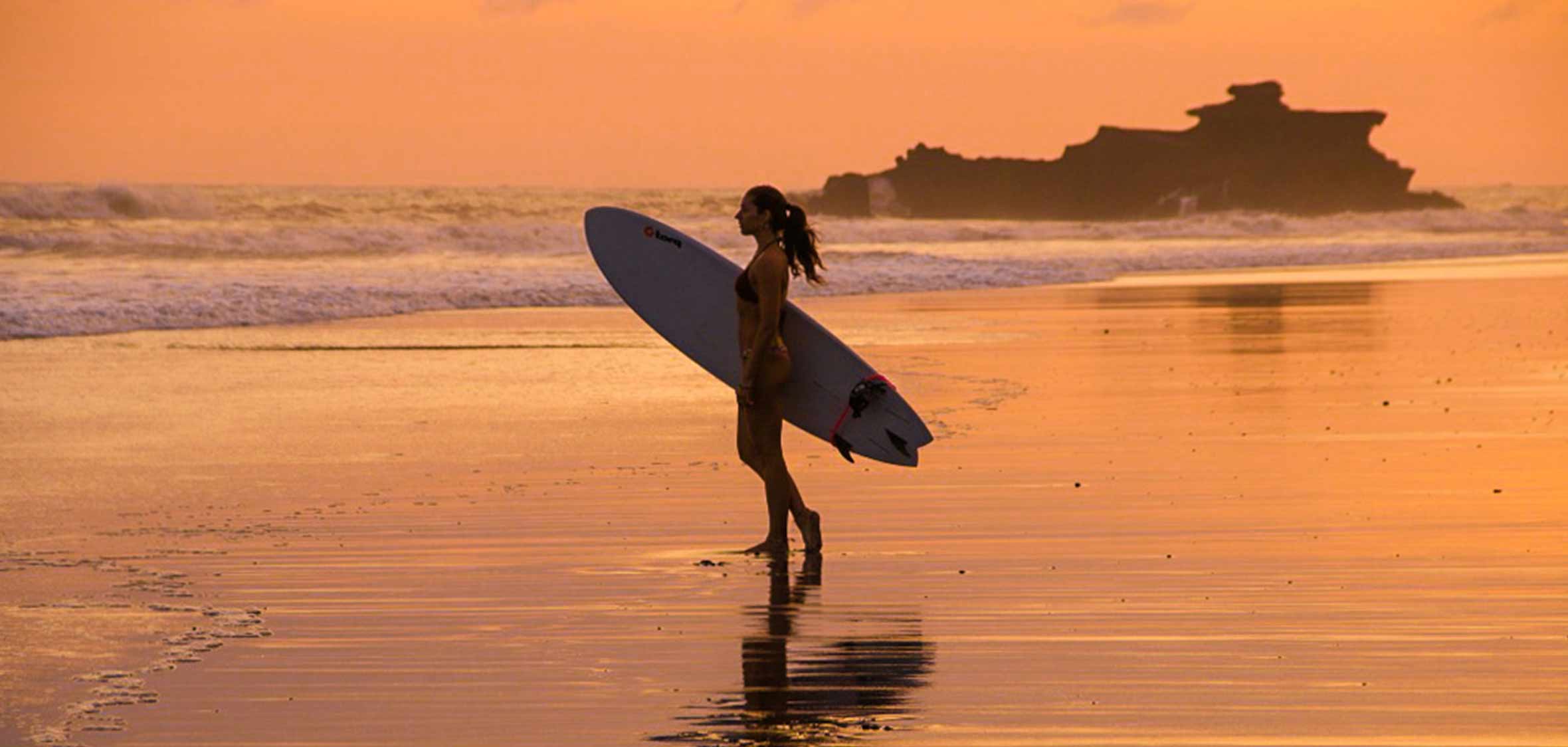 a surfer enjoys the sunset