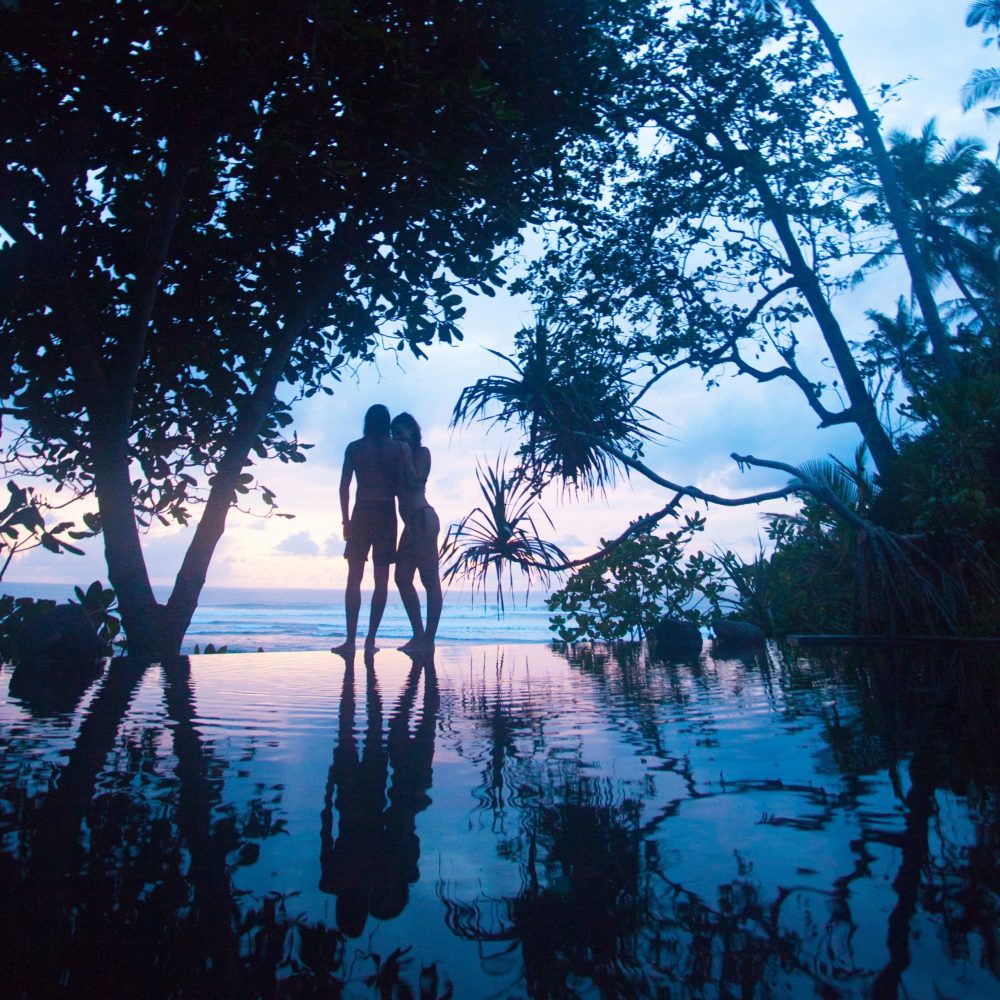 a romantic couple at sunset by the pool